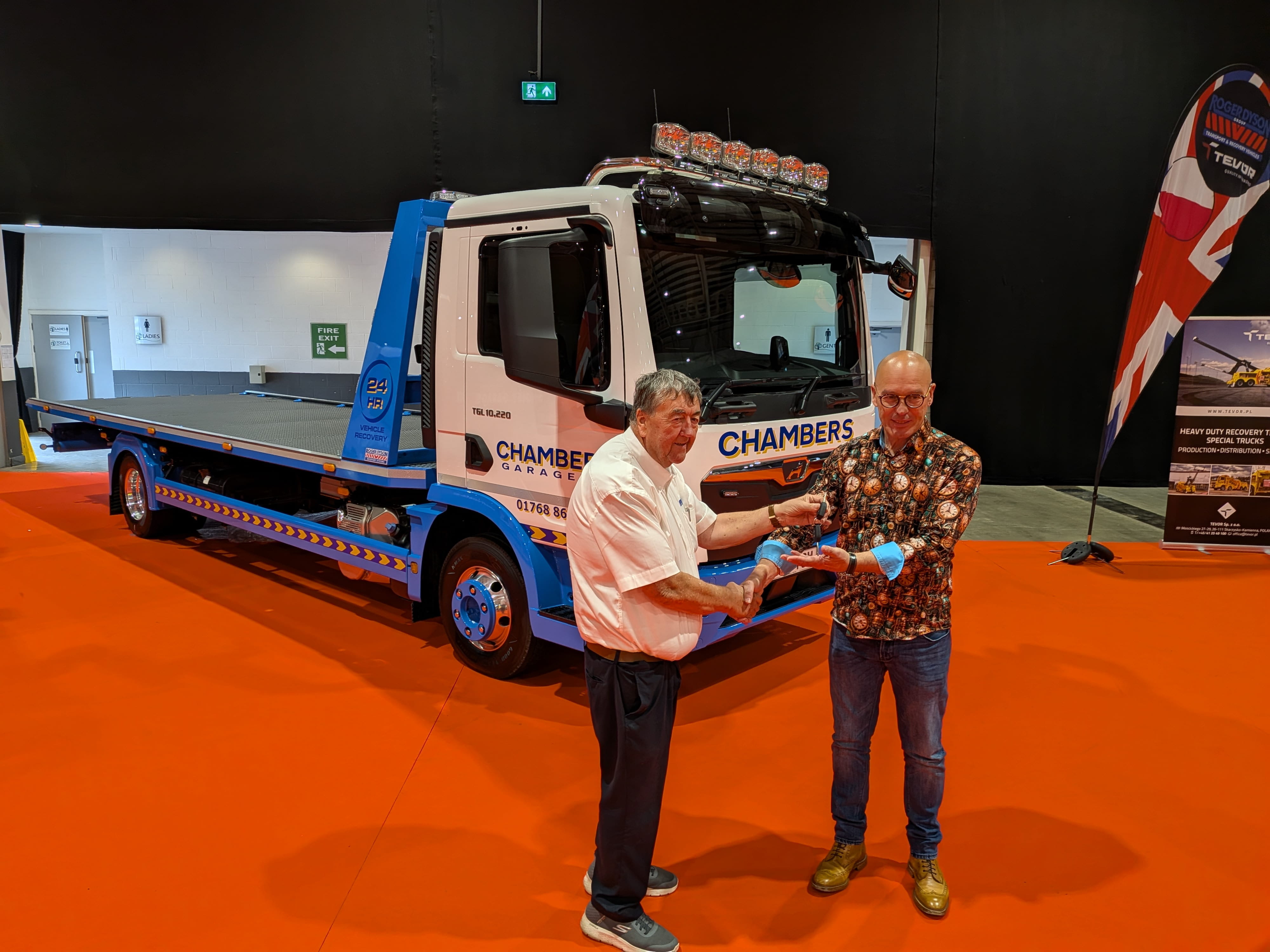 Keys being handed over in front of the new Chambers Garage MAN TGL 10.220 Roger Dyson Hydraloader recovery truck at a trade show