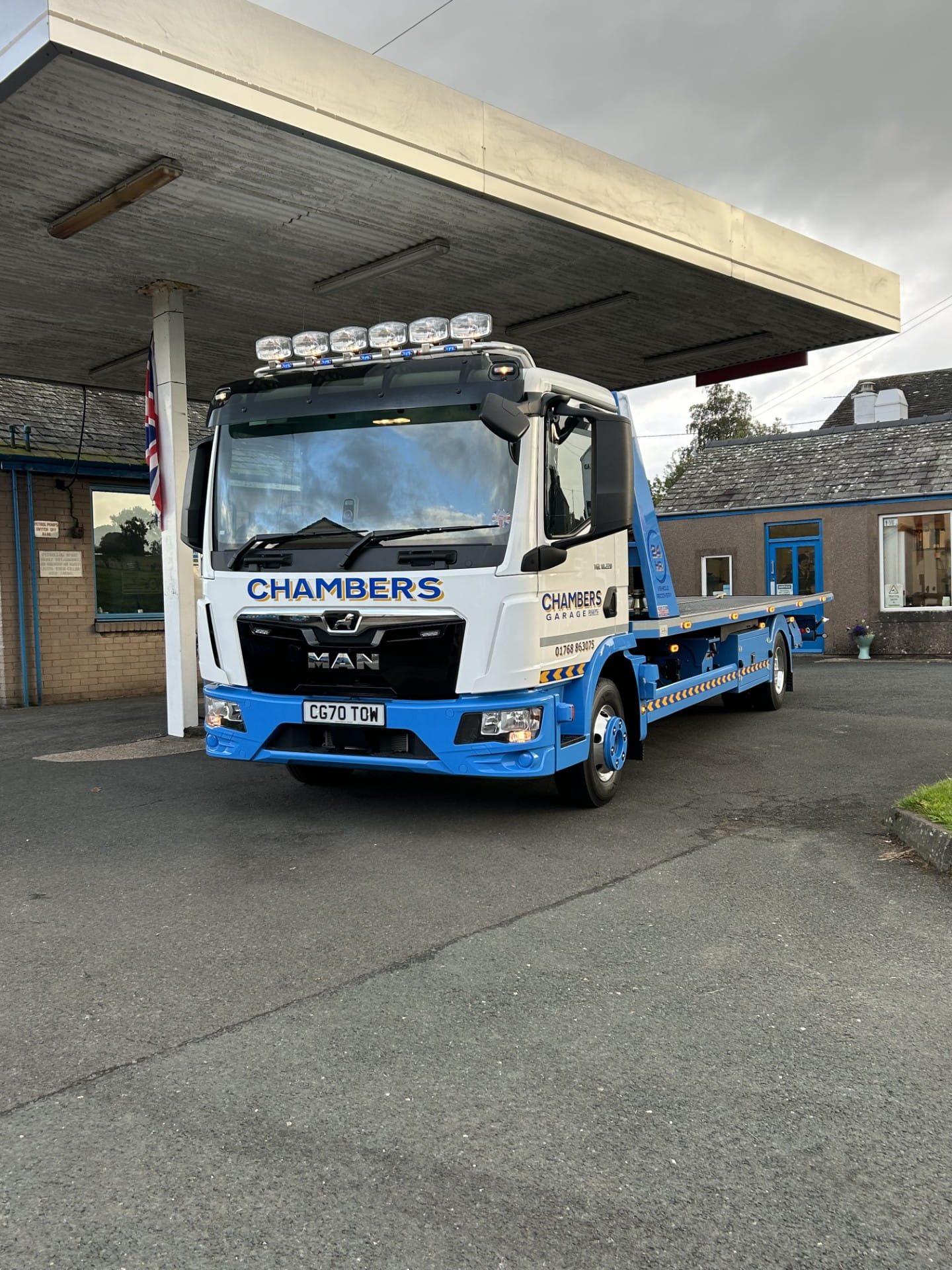 New white and blue Chambers Garage MAN TGL recovery truck with Roger Dyson Hydraloader body parked on the garage forecourt in Tirril, Penrith